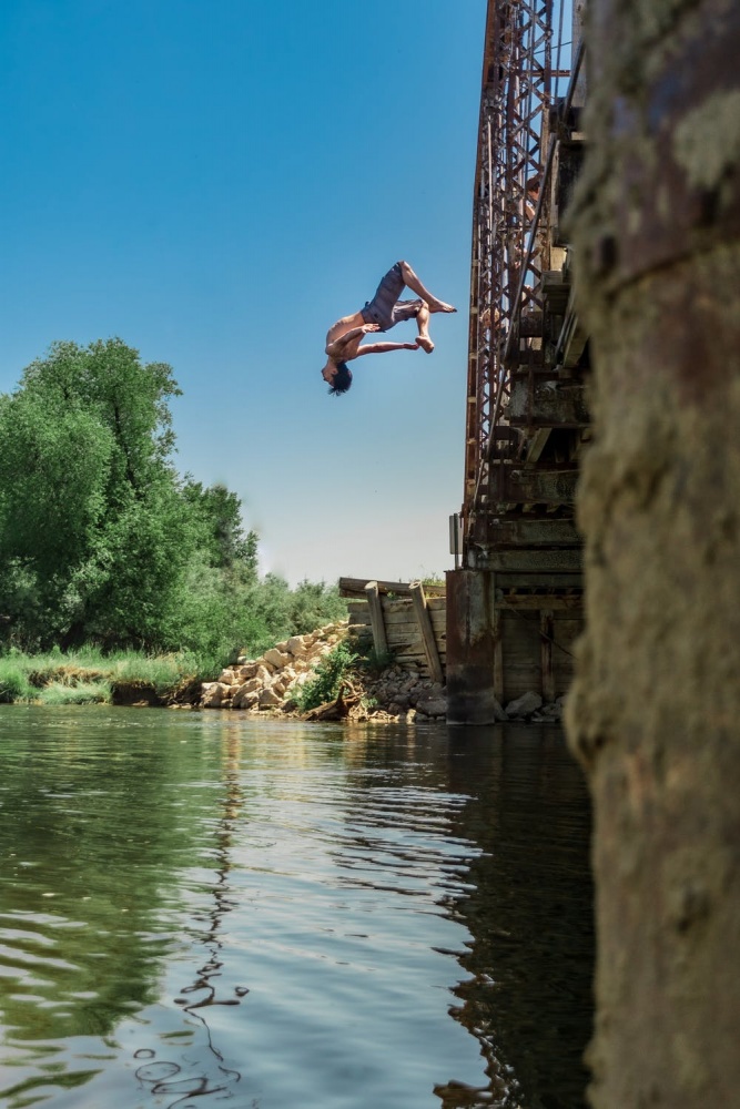 Person gör en volt från en bro ner i vattnet